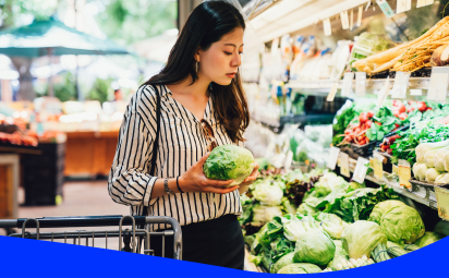Woman selecting fresh vegetables from supermarket