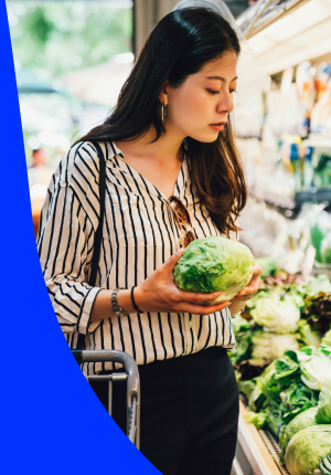 Woman selecting fresh vegetables from supermarket